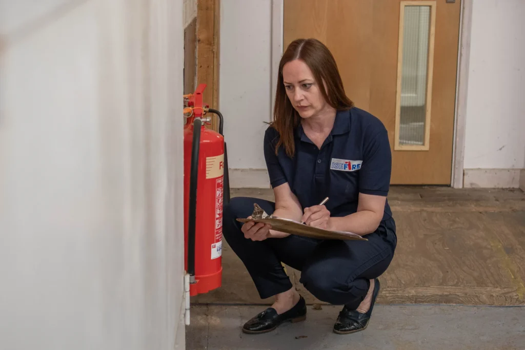 A Fire Alarm Systems engineer servicing a fire extinguisher