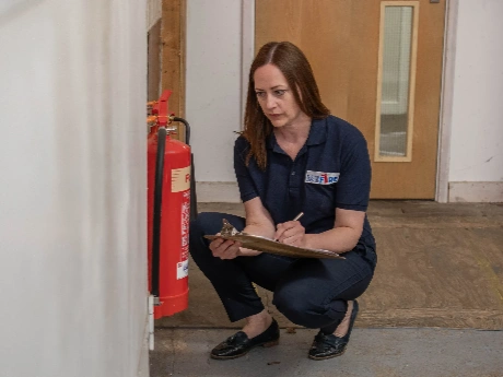 A Fire Alarm Systems engineer servicing a fire extinguisher