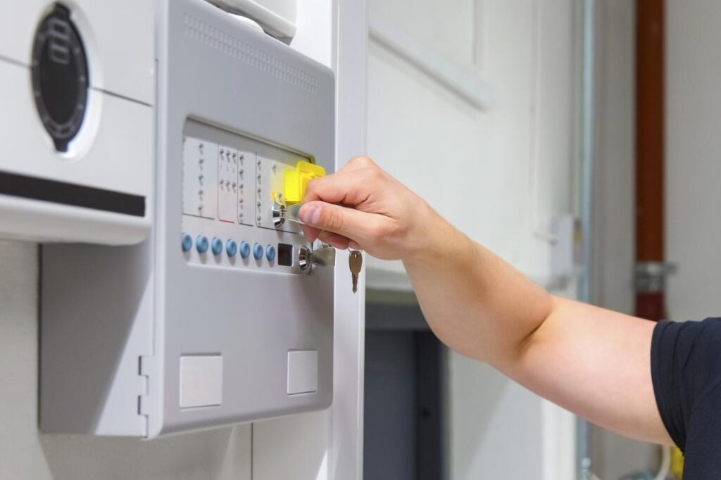 A service technician opening a fire alarm panel