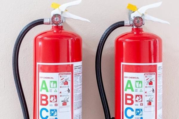 Two fire extinguishers labelled with an ABC fire class sticker