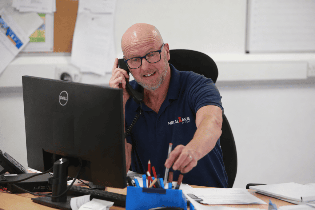 Fire Alarm Systems team member taking a customer call about commercial fire alarm servicing